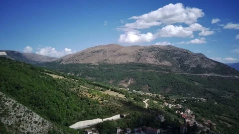 Flying drone over mountains with winding mountain road and forest. Italy Abruzzo Stock Footage 219746572