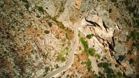 Flying drone over mountains with winding mountain road and forest Stock Footage 220192136
