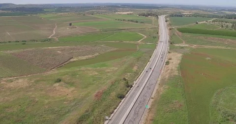 Flying with a drone over a road at the green fields of Israel Video stock 77763790