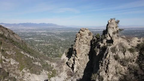 Flying drone over rock formation to reveal the Salt Lake Valley Stock Footage 153881140