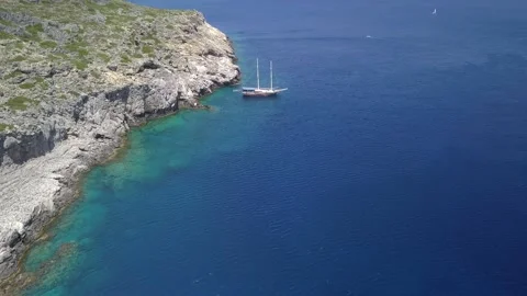 Flying by drone over the rocks, the sea with a view of the ship Stock Footage 158515418