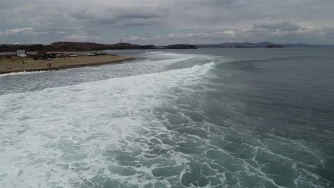 Flying a drone over the sea coast during big waves Stock Footage 179367553