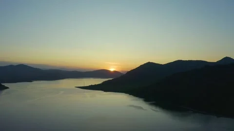 Flying on drone over a sunset lake among the mountains, east Kazakhstan, Bukhtar Stock Footage 242558996
