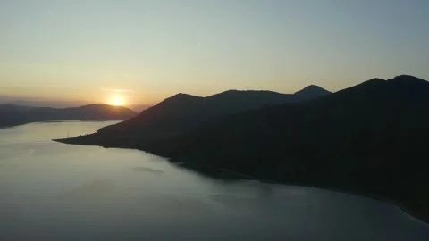 Flying on drone over a sunset lake among the mountains, east Kazakhstan, Bukhtar Stock Footage 242559248