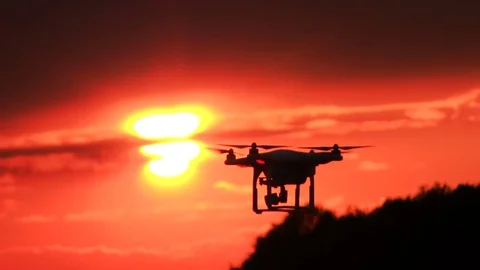 Flying drone rotate in  front of  sunset  red sky Video stock 76268920