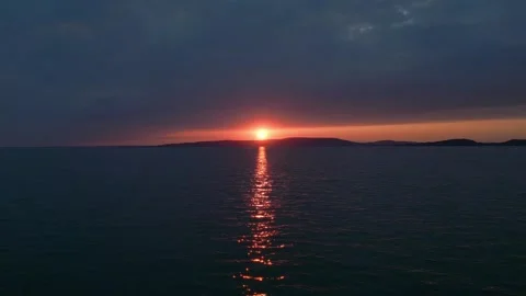 Flying the drone into the sunset over calm water Video stock 243091386