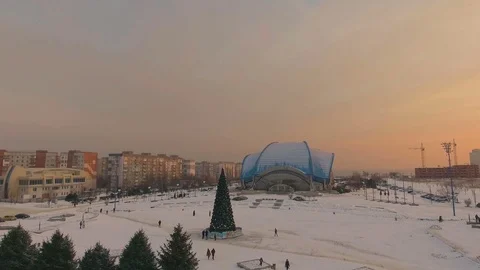 Flying drone at sunset over the central area of the city with a Christmas tree. Video stock 71463797