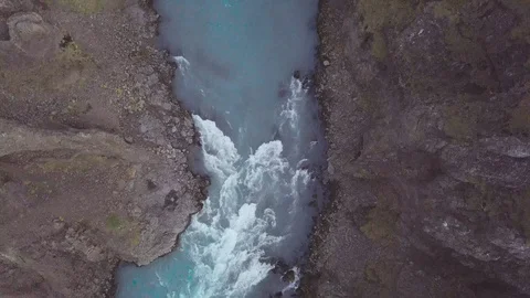 Flying a drone through a canyon with a river in iceland looking down Stock Footage 91270623