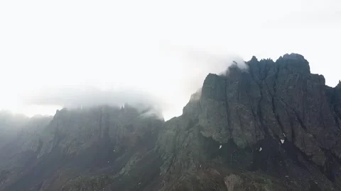 Flying with a drone through the clouds on the magnificent peaks of the Altiparma Stock Footage 251702683