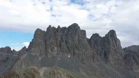 Flying with a drone through the clouds on the magnificent peaks of the Altiparma Stock Footage 251703076