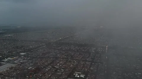 Flying a drone through low clouds over Ecatepec, as night falls on urban sprawl Stock Footage 312023836