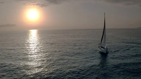 Flying drone view flight through across sail yacht to the sun. Video stock 108101118