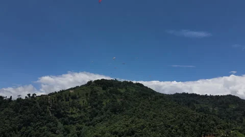 Flying a drone with a view of flying paragliding pilots on a sunny day. Stock Footage 245129148
