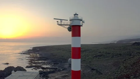 Flying drone view through the across the Lighthouse towards sunset Stock Footage 109217113