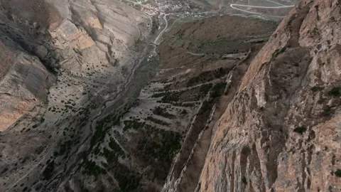 Flying eagle follow mountain stone structure desert valley village countryside Stock Footage 227360409