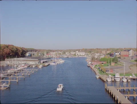 Flying fast and low over port and small town 1990s 35mm film Stock Footage 136385268