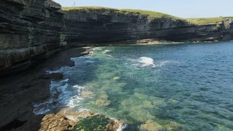 Flying flush with the water under the cliff Stock Footage 166199728