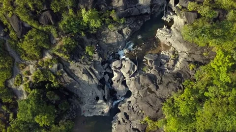 Flying forward bird’s-eye view showcasing waterfalls between rock formations in Video stock 301774268