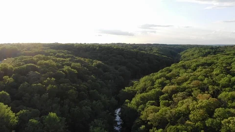 Flying forward over forest during sunset with river below Stock Footage 111345310