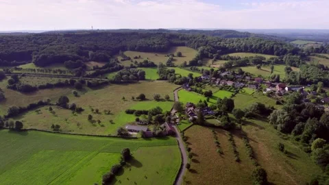 Flying forward over a rural road with small village, towards the forests 動画素材 195109014