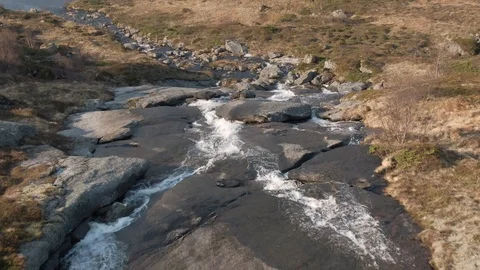 Flying Forward Over a Small Wide Waterfall In Lofoten Stock Footage 116358774