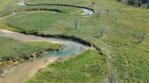 Flying forward over zigzagging river and green nature Stock Footage 107877876