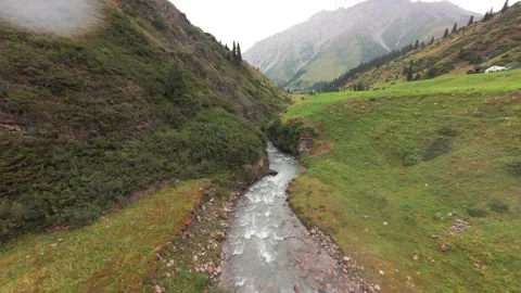 Flying a FPV drone along a gorge with a river Stock-Footage 296553513