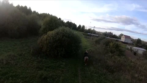 Flying on an fpv drone behind a horse, a girl on a horse Stock Footage 166834090