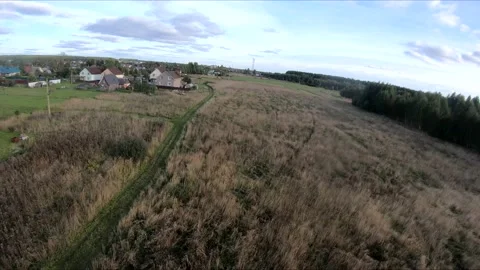 Flying on an fpv drone in a green field, against the background of a forest Stock Footage 166835642