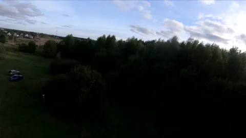 Flying on an fpv drone in a green field, against the background of a forest Stock Footage 166835669