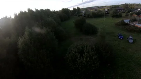 Flying on an fpv drone in a green field, against the background of a forest Stock Footage 166836159
