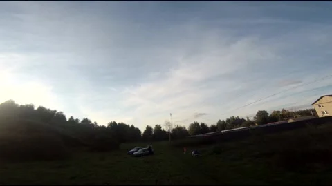 Flying on an fpv drone in a green field, against the background of a forest Stock Footage 166837879