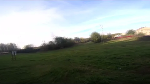 Flying on an fpv drone in a green field, against the background of a forest Stock Footage 166839759