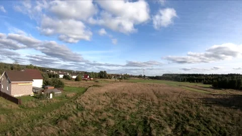 Flying on an fpv drone in a green field, against the background of a forest Stock Footage 166840429