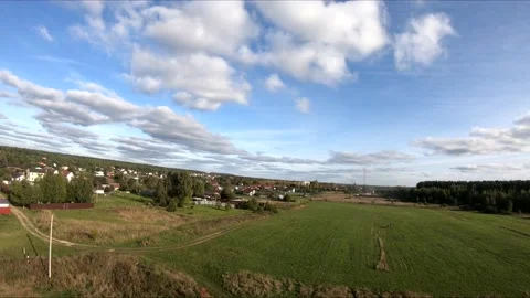 Flying on an fpv drone in a green field, against the background of a forest Stock Footage 166840517