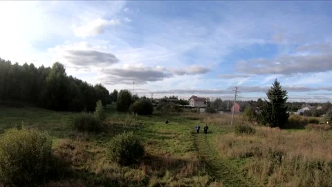 Flying on an fpv drone in a green field, against the background of a forest Stock Footage 166841530