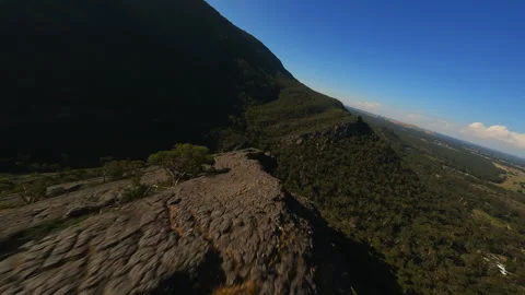 Flying on an FPV drone over the top of a cliff Stock Footage 244930216