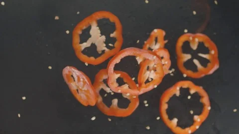 Flying fresh red bell pepper with slices and seeds on black background with fire Stock Footage 112222525