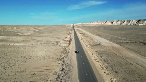 Flying in front of a car driving in a mountain desert Stock Footage 238462715