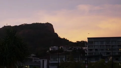 Flying fruit bats and birds soar across the setting sunlit skies with Castle Stock Footage 334722348