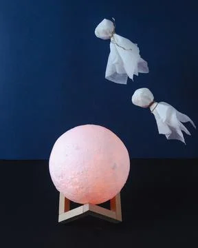 Flying ghosts in over the moon on dark background Stock Photos