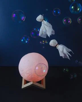 Flying ghosts over the moon on dark background Stock Photos