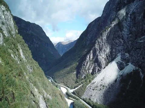 Flying in a Glacial Valley along Forested Mountainsides, Waterfall Backdrop Stock Footage 80968563