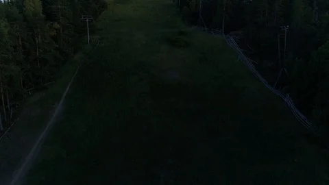 Flying up a grassy summer ski slope. Video stock 103352809