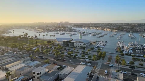 Flying into the harbor over building with a lighthouse with boats Stock Footage 198451949
