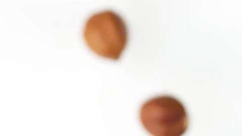Flying hazelnuts on the white background slow motion close up Video stock 148553207