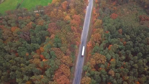 Flying high above container semi truck transporting goods on highway across t Stock Footage 81520910