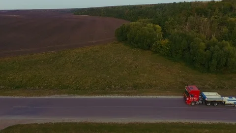 Flying high above freight semi truck transporting goods on busy highway across Video stock 99803136