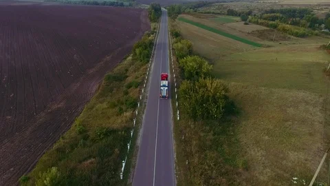 Flying high above freight semi truck transporting goods on busy highway across Video stock 99803253