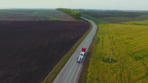 Flying high above freight semi truck transporting goods on busy highway across Video stock 99803675
